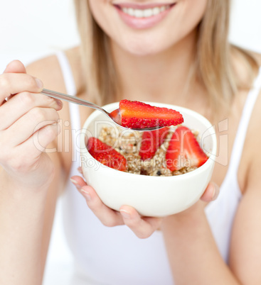 Close-up of a caucasian woman eating cereals with strawberries
