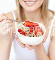 Close-up of a caucasian woman eating cereals with strawberries