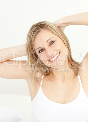 Charming woman stretching sitting on her bed