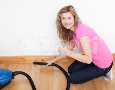 Portrait of a cheerful woman vacuuming