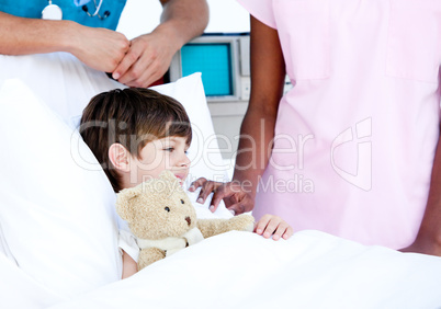 Adorable little boy hugging a teddy bear lying