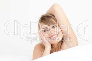 Delighted woman stretching sitting on her bed