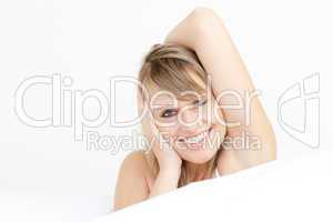Smiling woman stretching sitting on her bed