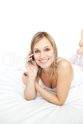 Happy woman talking on phone lying on her bed Happy woman talking on phone lying on her bed
