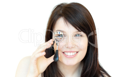 Cheerful teen girl using an eyelash curler