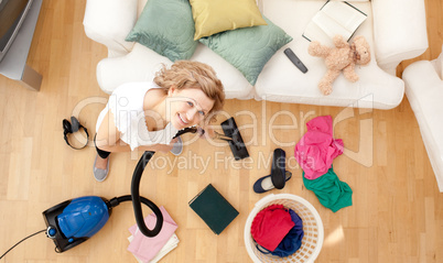 Smiling blond woman vacuuming the living-room