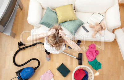 Depressed blond woman vacuuming the living-room
