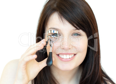 Charming teen girl using an eyelash curler