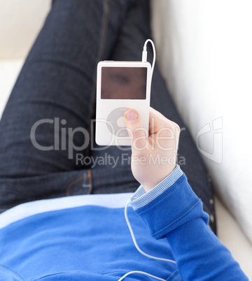 Close-up of a teen girl listening music lying on a sofa