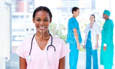 Confident female doctor standing with her team