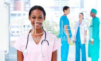 Confident female doctor standing with her team