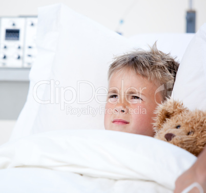 Sick little boy lying in a hospital bed