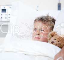 Sick little boy lying in a hospital bed