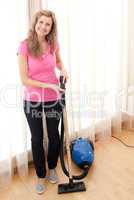 Portrait of a happy woman vacuuming