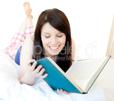 Portrait of a confident teen girl studying lying on a bed