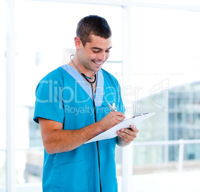 Concentrated male doctor making notes in a patient's folder