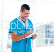 Concentrated male doctor making notes in a patient's folder