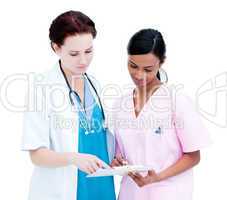 Assertive female doctor and nurse studying a patient's folder