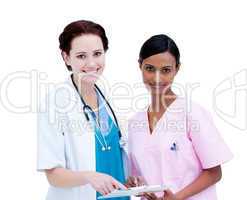 Sel-assured female doctor and nurse studying a patient's folder
