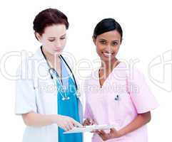 Confident female doctor and nurse studying a patient's folder