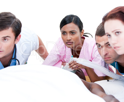 Assertive multi-ethnic medical team resuscitating a patient