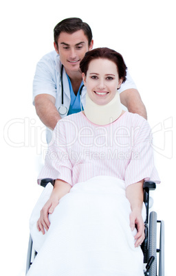 Attractive male doctor carrying a patient in a wheelchair
