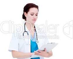 Serious caucasian female doctor making notes in a patient's fold