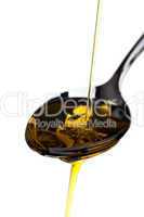 Olivenöl wird über einen Löffel gegossen