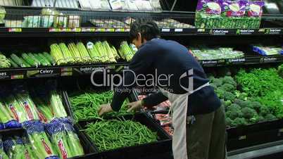 Man Inspecting Green Beans In Produce