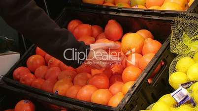 Woman Selecting Oranges In Produce