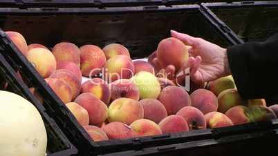 Woman Selecting Peaches In Produce