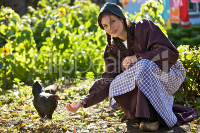 Woman feed chickens