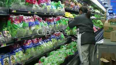 Woman Stocking Lettuce In Produce