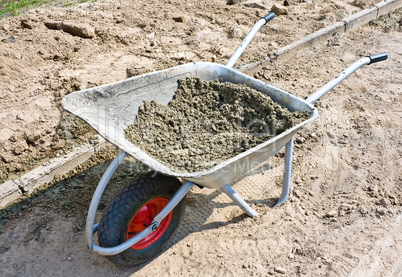 Wheelbarrow with mortar on road construction