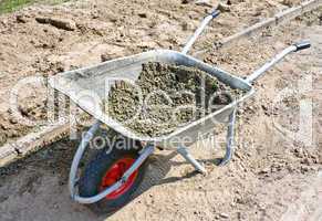 Wheelbarrow with mortar on road construction
