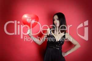 Beautiful girl with a red balloon in the form of heart