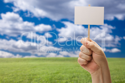 Blank Sign in Fist Over Grass Field and Sky