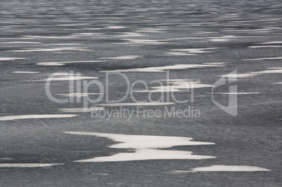 Snow drifts on frozen lake