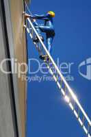 Bauarbeiter klettert eine Leiter hinauf