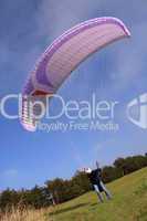 Purple paraglider launching