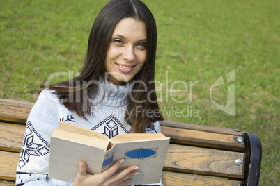 Young woman in a park with a book