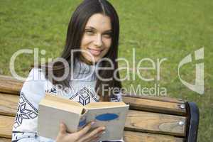 Young woman in a park with a book