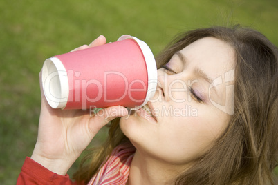 Female in a park drinking coffee