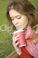 Female in a park drinking coffee