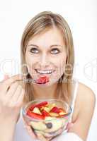 Jolly woman eating fruit salad