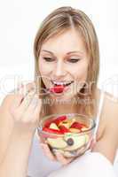 Charming woman eating fruit salad