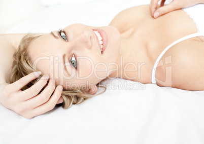 Glowing woman relaxing lying on her bed