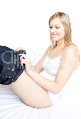 Smiling woman wearing a jeans on a bed