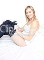 Happy woman wearing a jeans on a bed