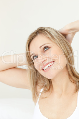 Happy woman stretching on her bed